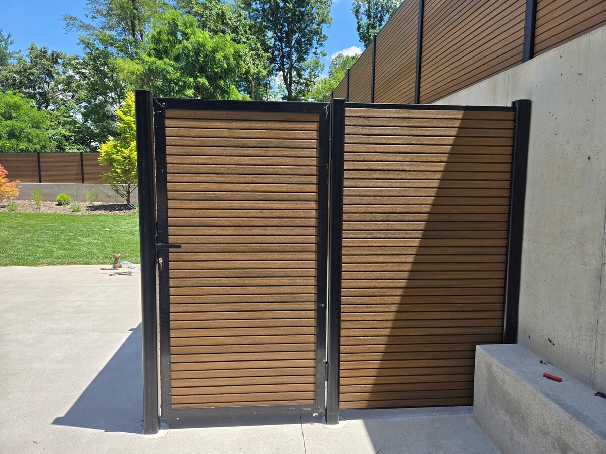 Bronze composite louvered privacy panels with a matching gate on a concrete pad