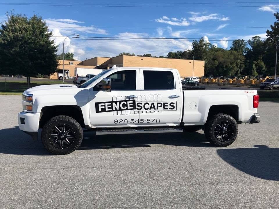 A white Fence Scapes pickup truck lettered with the company name and phone number 828-545-5711