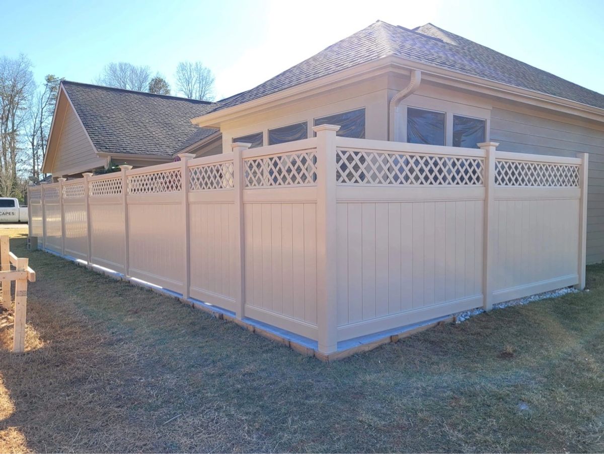 Tan vinyl privacy fence with lattice top