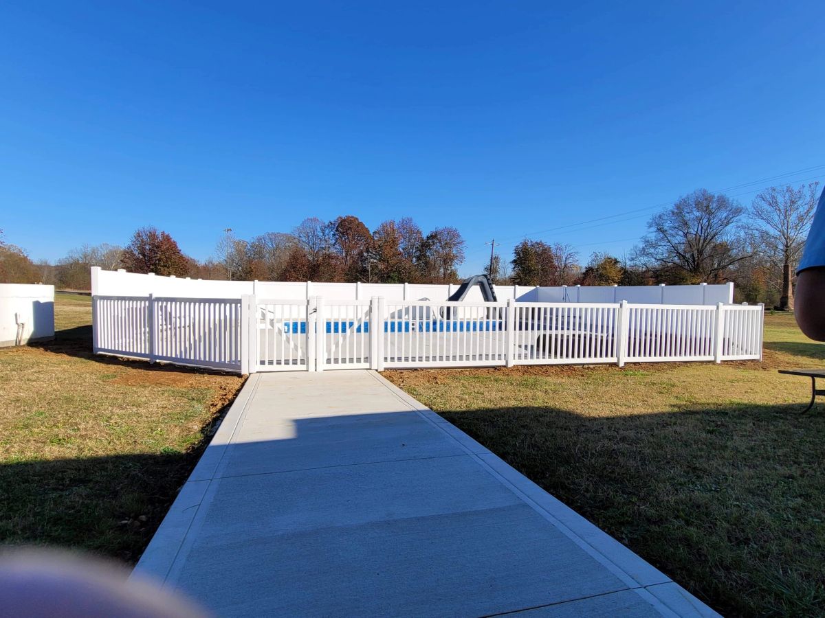 White vinyl privacy fence with pool picket section and gate